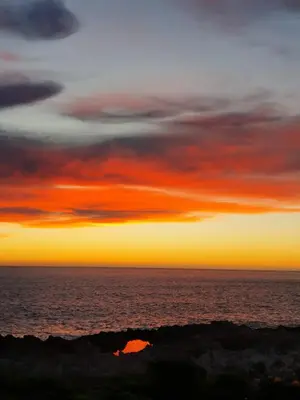 a sunset over the ocean with red clouds at Kleinblom in Pringle in Pringle Bay