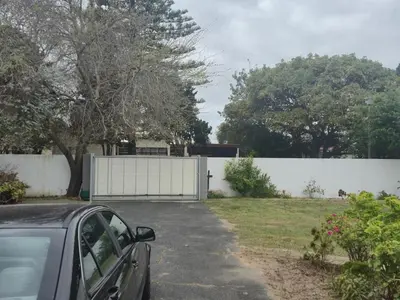 a car parked in front of a white fence at Lyronne Guest house, Shuttle and Tours in Cape Town