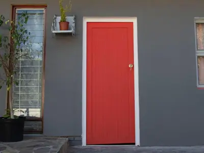 a red door on the side of a house at Lyronne Guest house, Shuttle and Tours in Cape Town