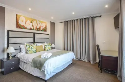 a hotel room with a bed and a desk and a desk at Casa Milner Guest House in Cape Town