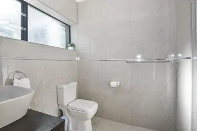 a white bathroom with a toilet and a sink at Casa Milner Guest House in Cape Town
