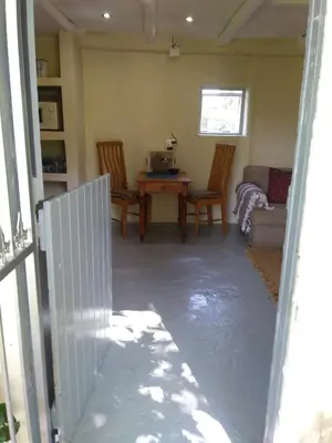 a living room with a table and chairs and a couch at Cabernet Cottage Be Still and Know in Franschhoek