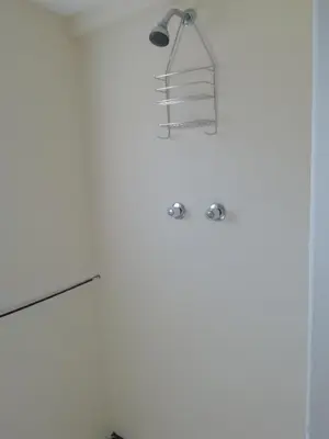a white bathroom with a towel rack on the wall at Cabernet Cottage Be Still and Know in Franschhoek