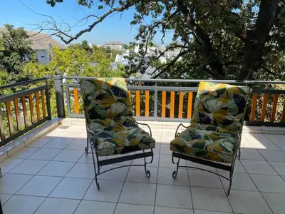 two chairs sitting on a balcony with a railing at Lemon Rind - 205 Oude Hoek in Stellenbosch