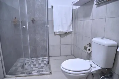 a bathroom with a toilet and a glass shower at 33onGill in Cape Town