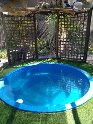 a small blue pool in a backyard with a pergola at 33onGill in Cape Town