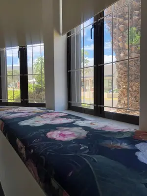 a bedroom with windows and a bed with a blanket at Villa Le Roc Kleinmond Accommodation in Kleinmond