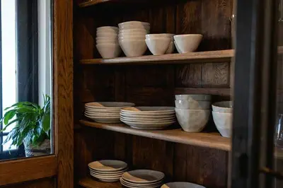 a shelf filled with bowls and plates and bowls at Villa Le Roc Kleinmond Accommodation in Kleinmond
