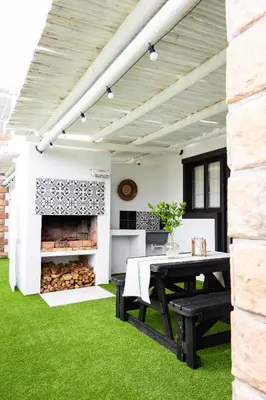 an outdoor patio with a table and a fireplace at Villa Le Roc Kleinmond Accommodation in Kleinmond