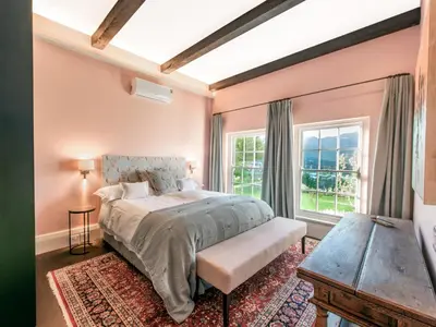 a bedroom with a bed and a window at The Vineyard Cottage by L' Amitie Estate in Franschhoek
