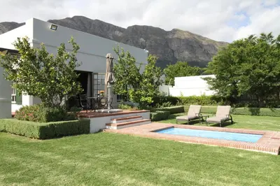 a house with a swimming pool in the yard at The Vineyard Cottage by L' Amitie Estate in Franschhoek