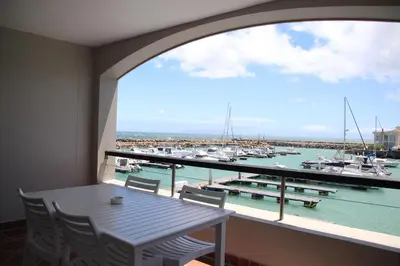 a balcony with a table and a view of a marina at The Boardwalk Accommodation in Gordonʼs Bay