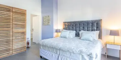a bedroom with a large bed with a large headboard at The Views Guesthouse in Somerset West
