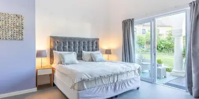a bedroom with a large bed and a large window at The Views Guesthouse in Somerset West