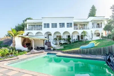 a large house with a swimming pool in front of it at The Views Guesthouse in Somerset West