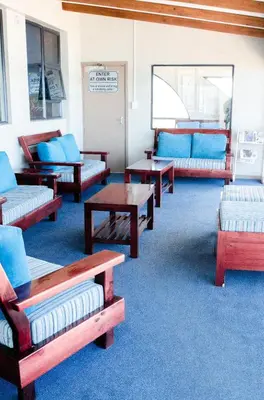 a room with couches and tables and blue carpet at Strand Pavilion in Strand