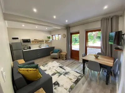 a living room with a couch and a dining room at Viettz Suite Annex in Stellenbosch