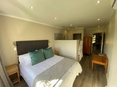 a bedroom with a large white bed with green pillows at Viettz Suite Annex in Stellenbosch