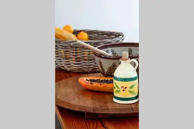 a table with a bottle and a basket of fruit at McFarlane Residence by Top Destinations Rentals in Hermanus