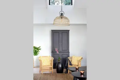 a room with a black door and two chairs and a table at McFarlane Residence by Top Destinations Rentals in Hermanus