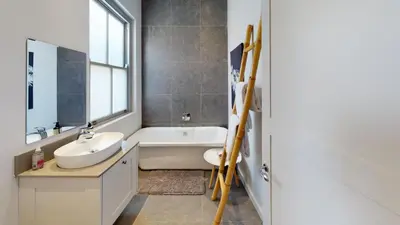 a bathroom with a sink and a bath tub and a window at McFarlane Residence by Top Destinations Rentals in Hermanus