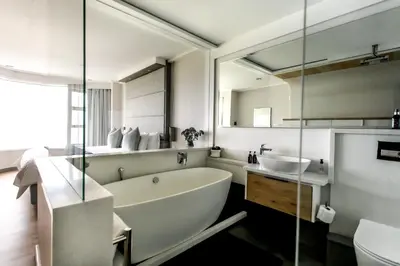 a bathroom with a large tub and a sink at Bayview 203 in Hermanus