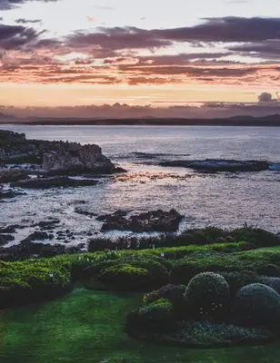 a view of the ocean from a golf course at sunset at Bayview 203 in Hermanus