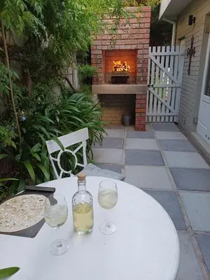 a table with two wine glasses and a fireplace at At Leisure in Worcester