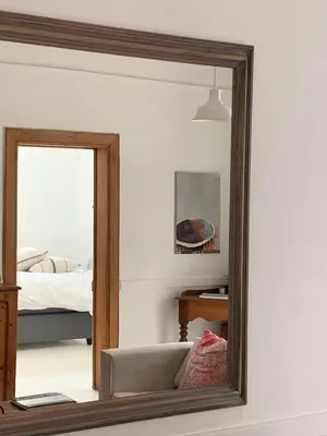 a mirror reflecting a room with a bed and a couch at The Missions House in Hermanus