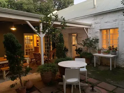 a patio with a white table and chairs at The Missions House in Hermanus