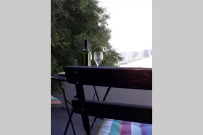 a table with a bottle of wine and a wine glass at Moondust near the ocean, food and wine in Hermanus