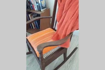 a wooden chair with an orange towel on it at Moondust near the ocean, food and wine in Hermanus