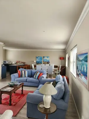 a living room with two blue couches and a table at Moondust near the ocean, food and wine in Hermanus