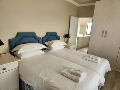 a bedroom with two beds with towels on them at Moondust near the ocean, food and wine in Hermanus