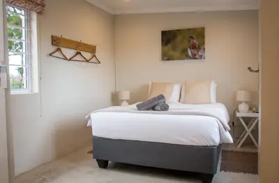 a bedroom with two beds and a bird picture on the wall at Moortop Cottages in Elgin