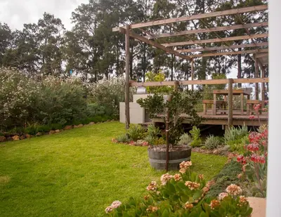 a garden with a wooden pergola and a bench at Moortop Cottages in Elgin