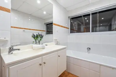a white bathroom with a sink and a tub and a sink at Ocean View 701 in Cape Town
