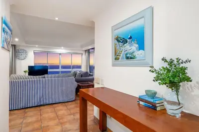 a living room with a table and a couch at Ocean View 701 in Cape Town