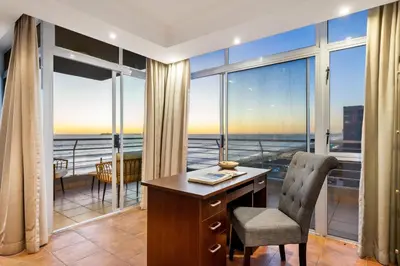 a desk and chair in a room with a large window at Ocean View 701 in Cape Town