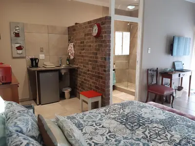 a living room with a bed and a brick wall at Goedehoop in Somerset West