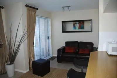 a living room with a couch and a table at On The Beach Front Sea Spray in Bloubergstrand