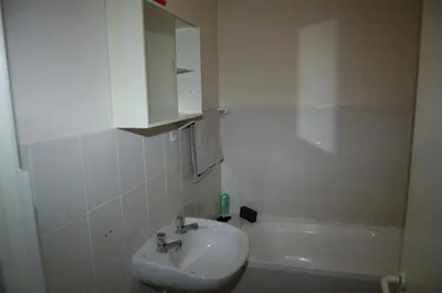 a white bathroom with a sink and a bath tub at On The Beach Front Sea Spray in Bloubergstrand