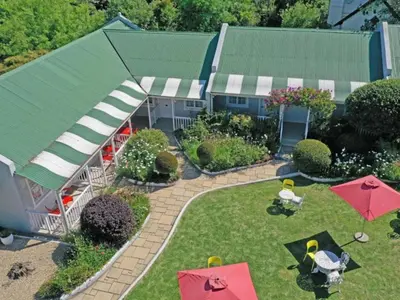an aerial view of a garden with umbrellas and a house at The Post House Hotel - no children under the age of 16yrs in Greyton
