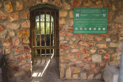 a door in a stone wall with a window at The Post House Hotel - no children under the age of 16yrs in Greyton