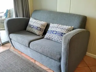 a gray couch with pillows on it in a room at OCEANPEARL 209 in Strand