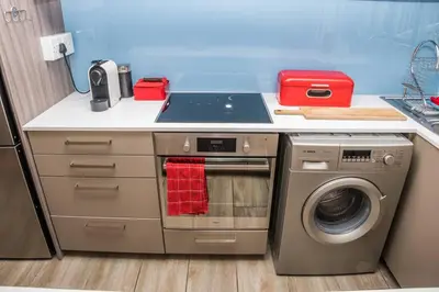 a kitchen with a stove and a washing machine at Apartment Claudia in Stellenbosch