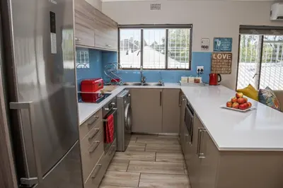 a kitchen with a stainless steel refrigerator and a sink at Apartment Claudia in Stellenbosch