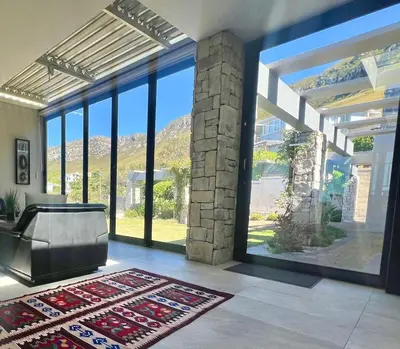 a living room with a large glass window and a tub at House Vos in Hermanus