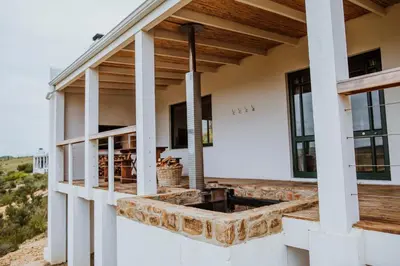 a house with a outdoor kitchen on the side of it at Blue Crane Farm Lodge in Botrivier