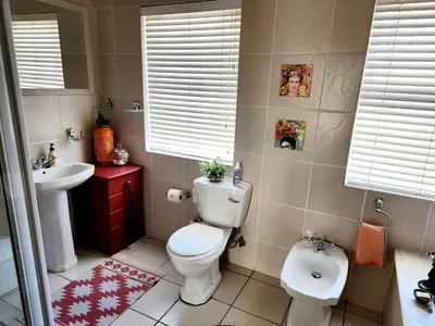 a bathroom with a toilet and a sink at Gordon's Beach Lodge in Gordonʼs Bay
